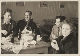 Photograph of Four People Gathered Round a Table